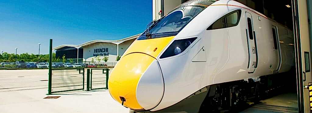 Hitachi train leaving factory building UK